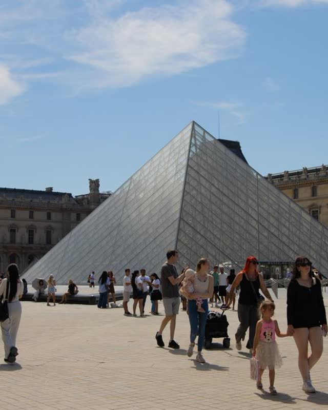 People in front of the Louvre pyramid in Paris