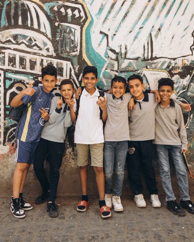Kids posing in front of a painted mural