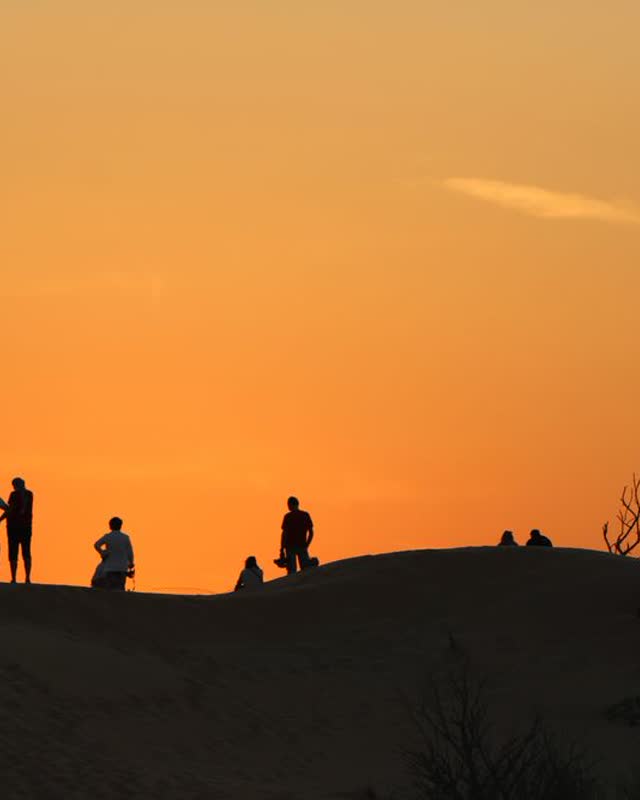 People on a hilltop at sunset